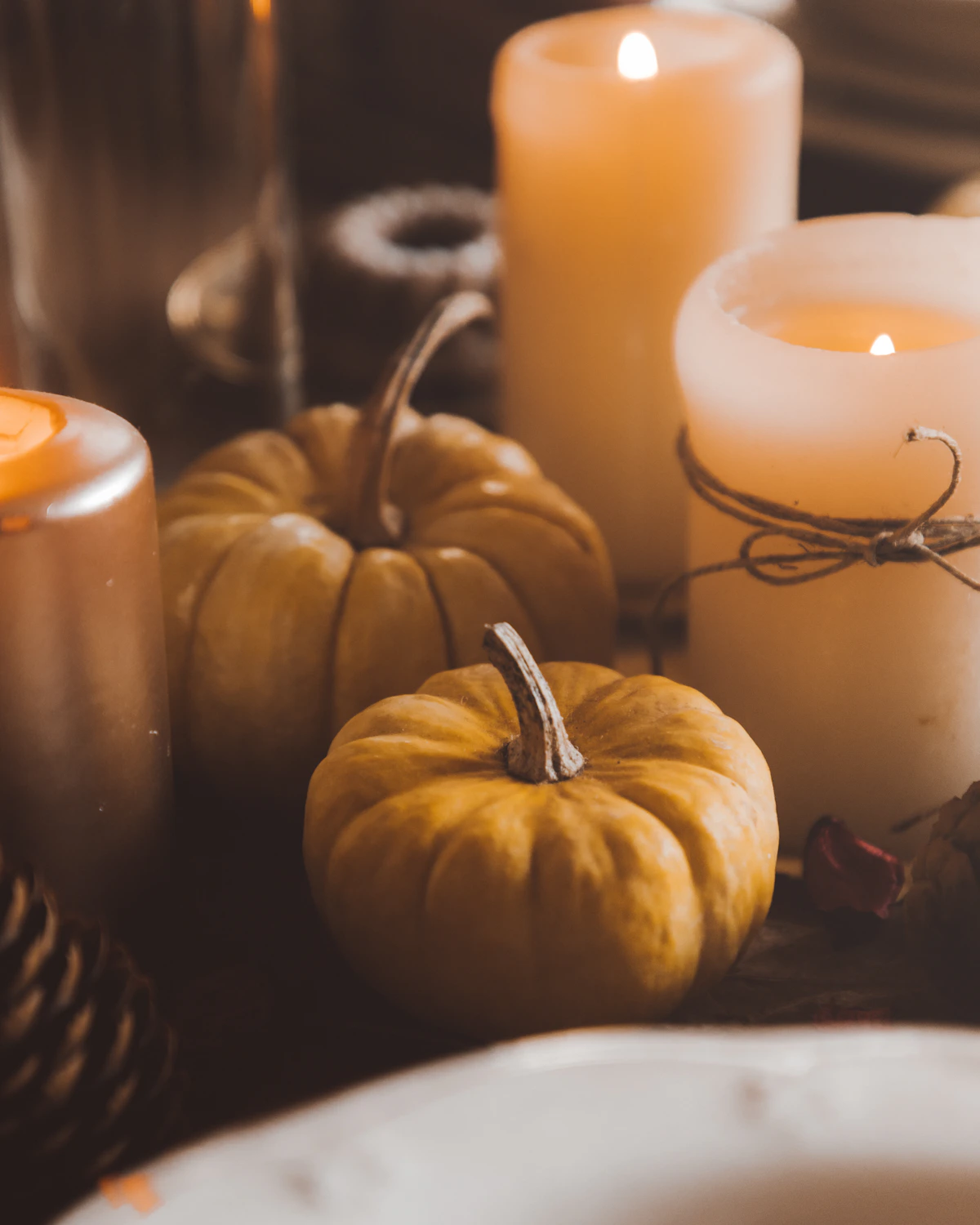 A harvest table with candles and pumpkins — illustrative photography